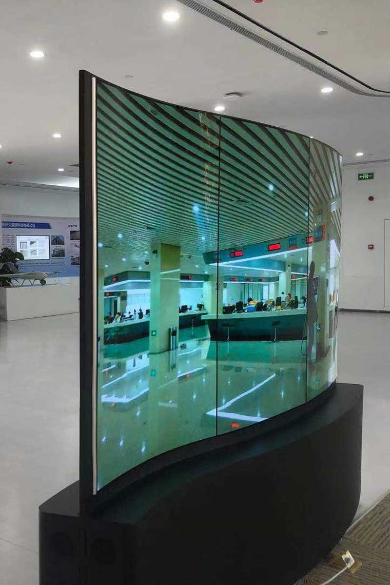 Three powered-on 65-inch flexible OLED displays installed vertically in one row
